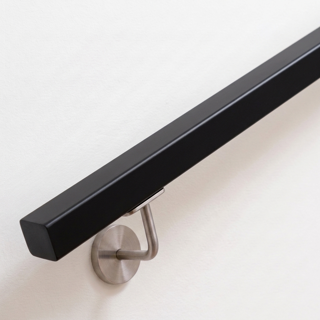 Handlauf Buche quadratisch schwarz lackiert mit Edelstahl-Handlaufhalter an weißer Wand, Ende gerade, Ansicht schräg von oben