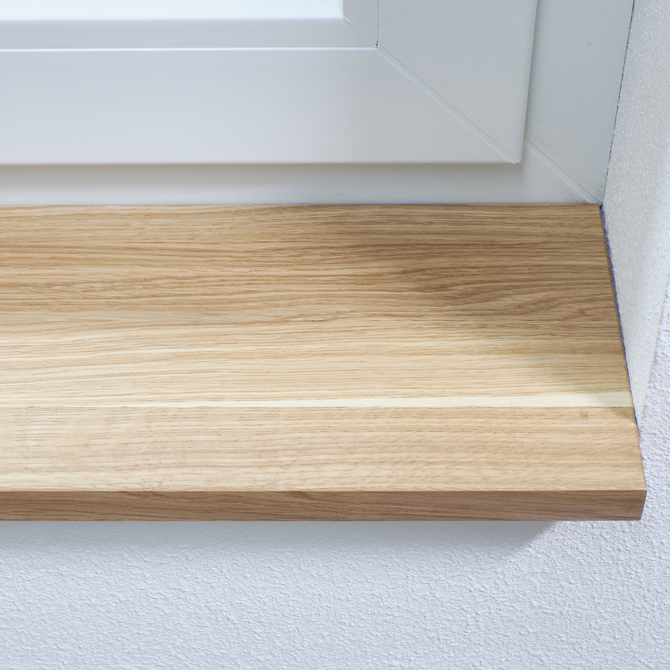Fensterbank Eiche massiv natur, eingebaut unter weißem Fensterrahmen, Nahaufnahme der Maserung