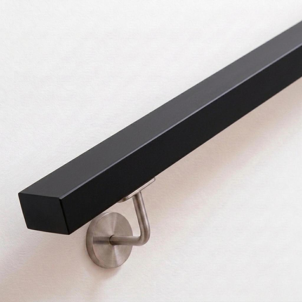 Handlauf Buche rechteckig schwarz lackiert mit Edelstahl-Handlaufhalter an weißer Wand, Ende gerade, Ansicht schräg von oben